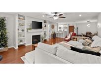 Open-concept living room featuring hardwood floors, a fireplace, built-in shelves, and neutral decor at 305 Ridley Howard Ct, Decatur, GA 30030