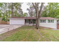 Charming single-story home featuring a lush front yard, attached two-car garage, and inviting front porch at 4100 Springlake Cir, Buford, GA 30519