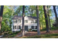 Charming white two-story home with black shutters surrounded by lush trees at 1508 Walker Ridge Sw Dr, Marietta, GA 30064