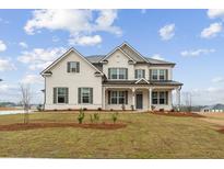 Charming two-story brick home with a welcoming front porch and lush green lawn at 321 Arwen Dr, Mcdonough, GA 30252