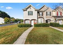 Charming townhome featuring a well-maintained lawn and inviting entryway at 6099 Camden Forrest Cv, Riverdale, GA 30296