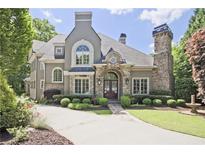 Stunning two-story home with stone accents, lush landscaping, and a circular driveway at 5118 Greythorne Ln, Marietta, GA 30068