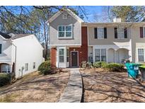 Two story townhouse with red brick, grey stucco, a walkway, and trees in the background at 6093 Camden Forrest Ct, Riverdale, GA 30296