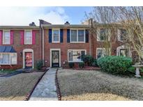 Charming brick townhome with manicured front yard and inviting walkway at 6118 Queen Anne Ct, Norcross, GA 30093