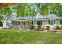 Charming single-story home with a welcoming front porch, lush green lawn, and mature trees providing shade at 45 Pine Tree Dr, Mcdonough, GA 30252