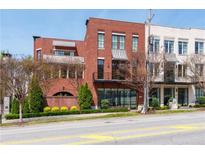 Beautiful brick multi-story townhome featuring awnings, large windows, and professional landscaping at 89 E Andrews Nw Dr, Atlanta, GA 30305