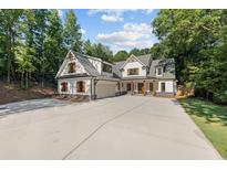 New construction home with a large driveway, lawn, and professionally designed exterior at 535 Shamrock Dr, Cumming, GA 30040