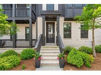 Inviting home exterior showcasing a brick facade, landscaped front yard, and a charming entryway with decorative plants at 933 Catamaran Ct, Alpharetta, GA 30005