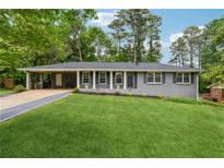Charming single-story home with a well-manicured lawn and convenient carport at 1154 Pair Sw Rd, Marietta, GA 30060
