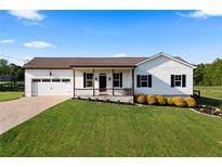 Charming home with white siding, a covered porch, a well-manicured lawn, and an attached garage at 275 Crowe Springs Nw Rd, Cartersville, GA 30121