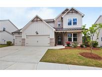 Charming two-story home boasts a three-car garage and well-manicured front yard at 2436 Hidden Creek Road, Kennesaw, GA 30152