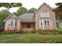 Charming two-story home featuring a well-maintained lawn and landscaped garden with vibrant red flowers at 5665 Stewart Woods Dr, Douglasville, GA 30135