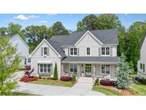 Charming two-story home with gray siding, dark shutters, a welcoming front porch, and beautifully landscaped front yard at 107 Owens Mill Place, Canton, GA 30115