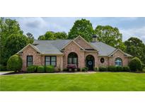 Charming brick home with manicured lawn and mature landscaping, creating inviting curb appeal at 710 Eastbourne Ct, Alpharetta, GA 30005