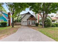 Charming two-story home with a well-maintained front yard and a driveway leading to a single-car garage at 969 Oak Sw St, Atlanta, GA 30310