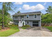 Charming two-story home with gray siding, white trim, landscaped yard, and attached one-car garage at 1501 Jamerson Landing, Marietta, GA 30066