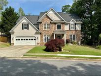 Charming two-story home featuring stone and shingle siding, well-manicured lawn, and attached two-car garage at 1782 Telfair Chase Way, Lawrenceville, GA 30043