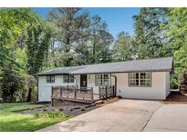 Charming renovated home with a deck, landscaped front yard, and a modern white exterior at 30 Dewey Se Ln, Marietta, GA 30060