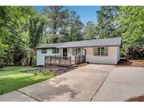 Charming single-story home with white siding, a welcoming front porch, and a well-maintained front yard at 30 Dewey Se Ln, Marietta, GA 30060