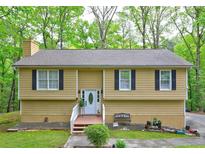 Inviting front exterior of home with white trim and black shutters surrounded by lush green trees at 3452 Chesterfield Ct, Snellville, GA 30039