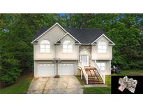 Charming two-story home with two-car garage, landscaped yard, and inviting front entrance, nestled among mature trees at 59 Abbotsford Dr, Villa Rica, GA 30180