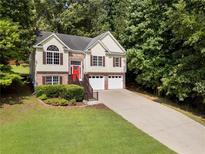 Charming two-story home with a brick facade, a vibrant red front door, and a well-manicured lawn at 136 Walkers Pond Dr, Villa Rica, GA 30180