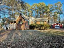 Charming brick home with a covered porch and a detached garage nestled among mature trees at 342 Mccurry Rd, Stockbridge, GA 30281