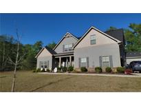 Charming two-story home with neutral siding, black roof, lush landscaping, and a welcoming covered front porch at 101 Ruby Lane, Mcdonough, GA 30252