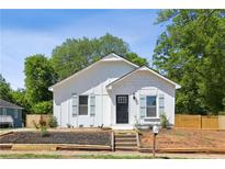Charming white home featuring blue shutters, a black front door, and a newly landscaped yard at 130 South Se Ave, Marietta, GA 30060