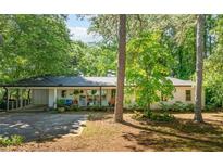 Charming single-story home with a white facade, covered porch and lush landscaping at 3294 Mcclure Bridge Rd, Duluth, GA 30096