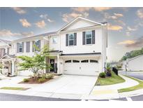 Charming two-story townhouse with a two-car garage, beautiful landscaping and a welcoming entrance at 500 Garvin Dr, Woodstock, GA 30189