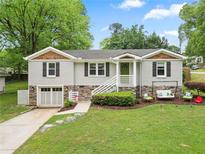 Charming home featuring a stone accent front, green lawn, and inviting front porch swing at 984 Ridgecrest Se Dr, Smyrna, GA 30080