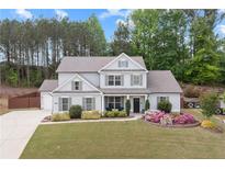 Charming two-story home with landscaped yard, lush green lawn and beautiful flowering shrubs in the flower beds at 124 Grand Oaks Dr, Canton, GA 30115