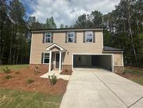 Charming two-story home with neutral siding, large driveway and well-manicured front yard at 25 Yellow Brick Way, Covington, GA 30014