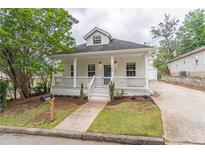 Charming two-story home with a inviting front porch and well-manicured lawn and garden at 1555 New Ne St, Atlanta, GA 30307