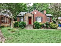 Charming brick home with a red door, stone accents, and a well-manicured front lawn at 1798 Melrose Sw Dr, Atlanta, GA 30310