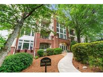 A brick condominium building with mature trees and well-manicured landscaping at 3636 Habersham Nw Rd # 2101, Atlanta, GA 30305