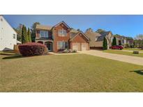Charming two-story brick home with a well-manicured lawn and two-car garage at 103 Harvest Rdg, Acworth, GA 30102