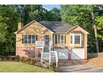 Inviting two-story home featuring a brick foundation, white stairs, and a charming facade at 2114 Lindley Nw Ln, Kennesaw, GA 30144