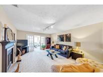 Bright living room featuring a fireplace, plush seating, and sliding doors leading to an outside living space at 4118 Stillwater Dr, Duluth, GA 30096