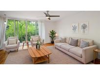 Bright living room features a ceiling fan, hardwood floors, and sliding glass doors to a balcony with a scenic view at 120 Alden Nw Ave # C3, Atlanta, GA 30309