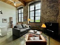 Spacious living room features exposed brick, large windows, and modern furnishings at 170 Boulevard Se # H301, Atlanta, GA 30312