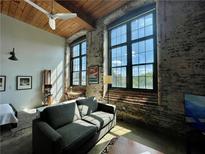 Bright living room with exposed brick, wood ceilings, and large windows offering ample natural light at 170 Boulevard Se # H301, Atlanta, GA 30312