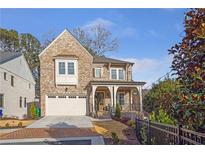 Charming brick two-story home with manicured landscaping, attached garage, and inviting curb appeal at 4505 Caroline Walk, Dunwoody, GA 30338