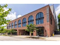 Brick building with arched windows and covered parking at Pullman Flats, Atlanta at 112 Rogers St # 208, Atlanta, GA 30317