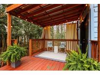 Inviting covered patio featuring string lights, wood deck, and a cozy seating area with decorative cushions at 1350 Overlook Se Cv, Smyrna, GA 30080