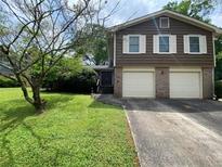 Charming split-level home with a two-car garage and well-maintained front lawn at 4457 Huntshire Dr, Stone Mountain, GA 30083