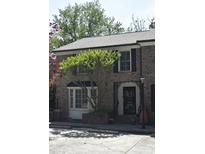 Charming brick home featuring a bay window, black shutters, and an ornamental iron front door gate at 11 Ardmore Nw Sq, Atlanta, GA 30309