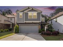 Charming two-story home with a two-car garage and gray siding, complemented by manicured landscaping at 2769 Morgan Spring Trl, Buford, GA 30519
