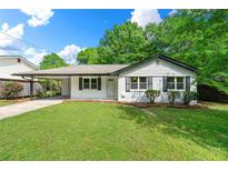 Charming single-story home features a lush green lawn, inviting entrance, and a convenient carport at 2125 Lynn Sw Dr, Marietta, GA 30060